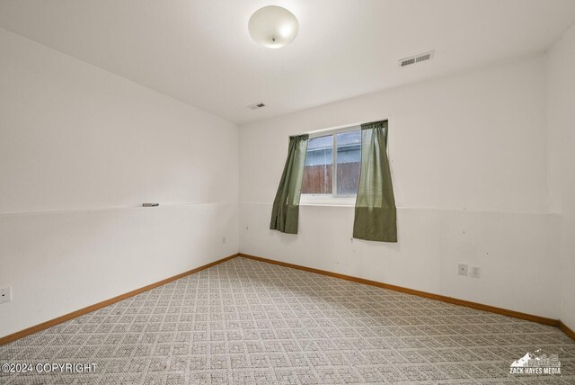 unfurnished room featuring light carpet