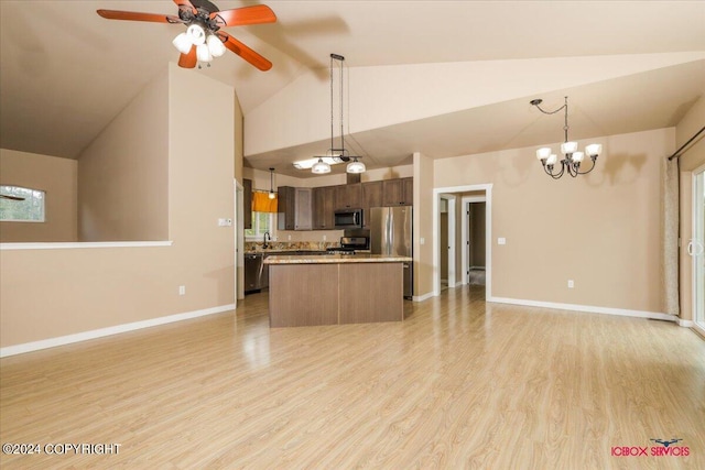 kitchen with light wood-type flooring, ceiling fan with notable chandelier, sink, hanging light fixtures, and appliances with stainless steel finishes