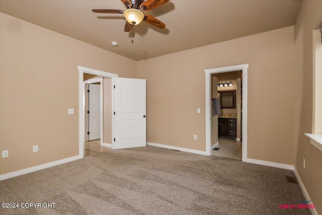 unfurnished bedroom with ensuite bath, light carpet, and ceiling fan