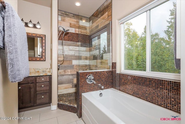 bathroom with vanity, a wealth of natural light, independent shower and bath, and tile patterned flooring