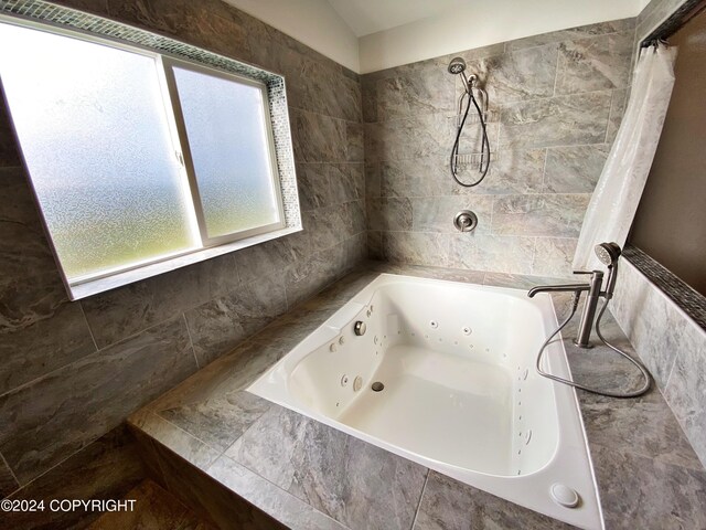 bathroom featuring shower with separate bathtub and tile walls