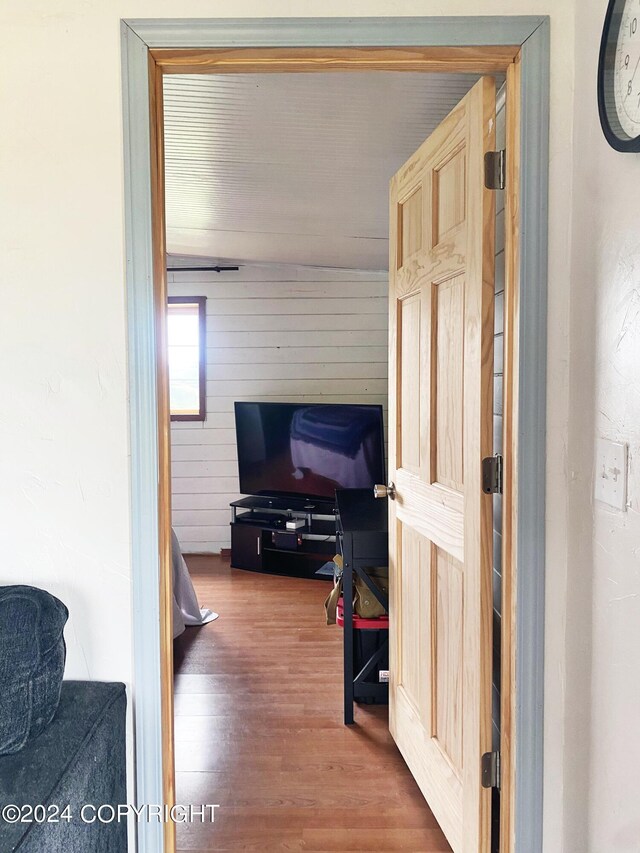 hallway featuring wooden walls and hardwood / wood-style floors