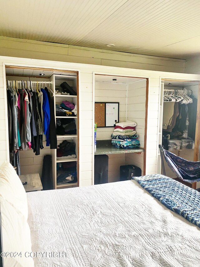 bedroom featuring wooden walls