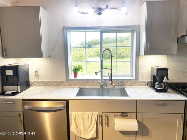 kitchen with sink, tasteful backsplash, gray cabinetry, stainless steel dishwasher, and range