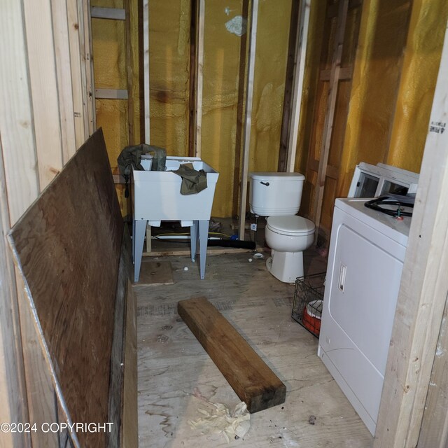 bathroom with toilet and washer / clothes dryer