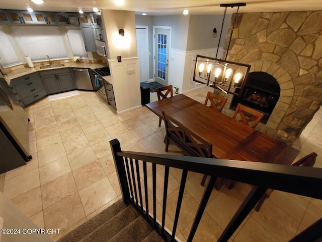 interior space featuring wainscoting, a fireplace, a decorative wall, and light tile patterned floors