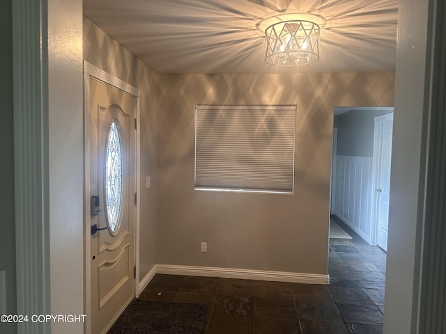 entryway with stone finish floor and baseboards