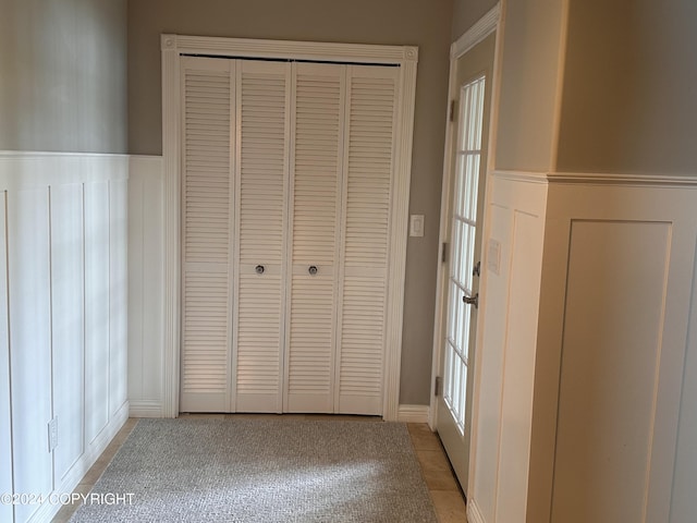 unfurnished bedroom with a wainscoted wall and a closet