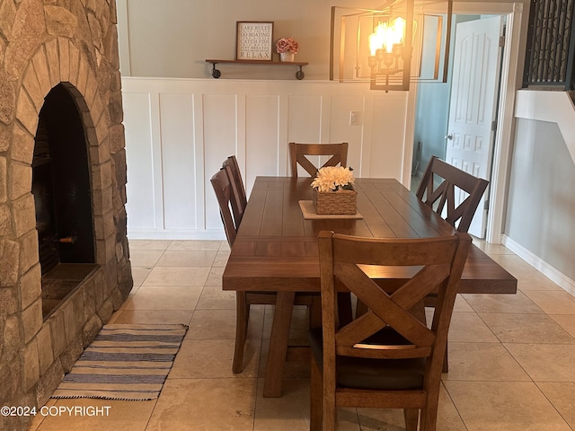 dining space with light tile patterned floors and a decorative wall