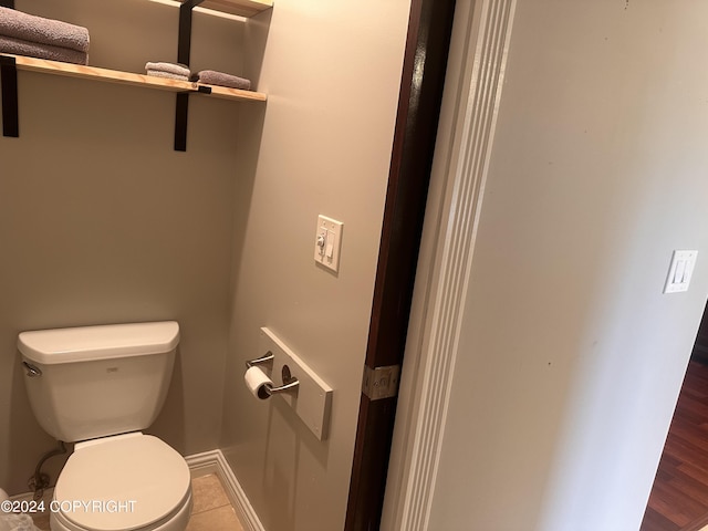 bathroom with baseboards and toilet