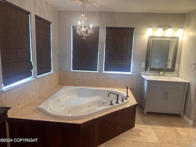 full bath with a chandelier, vanity, a whirlpool tub, and tile patterned floors