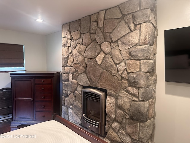 unfurnished bedroom featuring recessed lighting, a stone fireplace, and wood finished floors