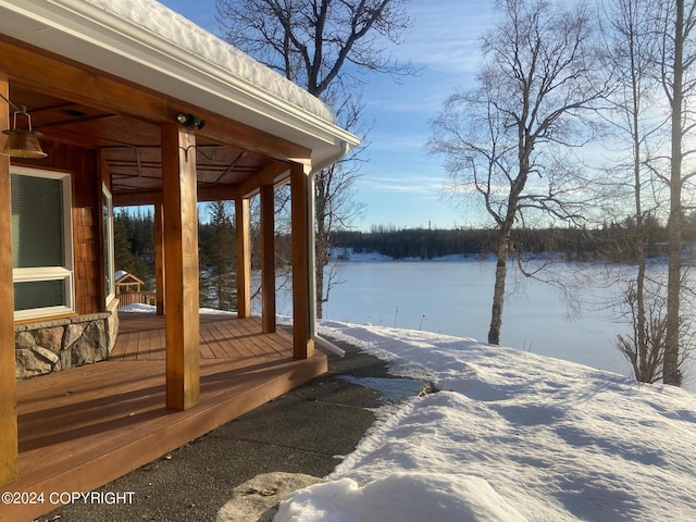 snow covered deck featuring a water view