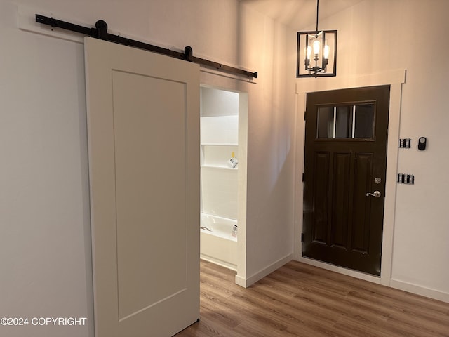 entrance foyer featuring a barn door, baseboards, and wood finished floors