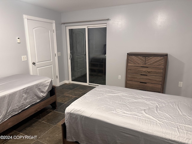 bedroom featuring stone finish flooring, baseboards, and a closet