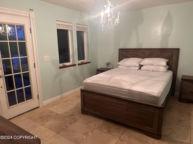 tiled bedroom with baseboards and a notable chandelier