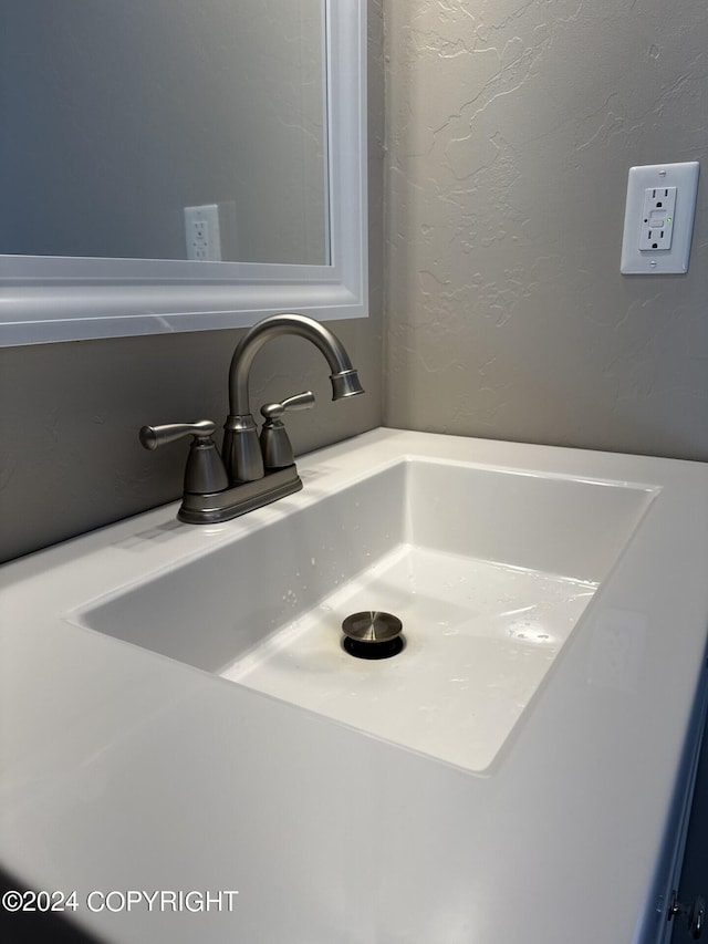 room details featuring a textured wall and a sink