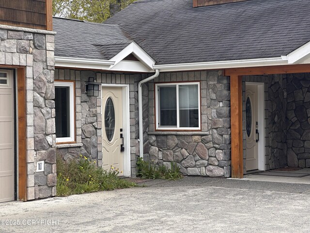 52305 Admiralty Dr, Nikiski/North Kenai, AK 99611 - doorway to property with stone siding, roof with shingles, and a garage