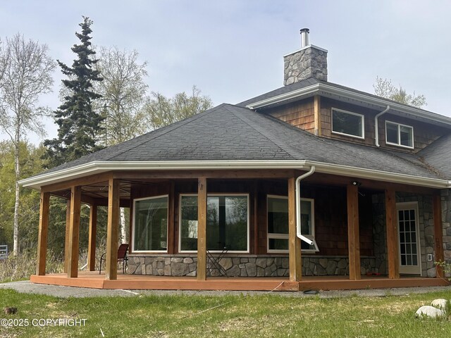 52305 Admiralty Dr, Nikiski/North Kenai, AK 99611 - back of property featuring roof with shingles, stone siding, a chimney, and a porch