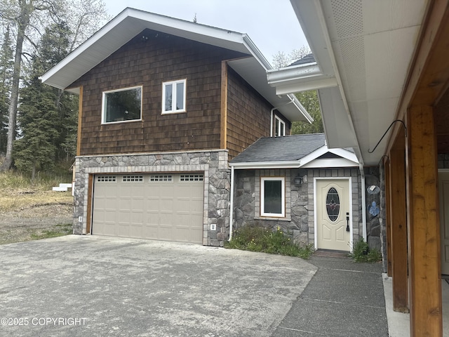 52305 Admiralty Dr, Nikiski/North Kenai, AK 99611 - view of front of house with stone siding, a garage, and driveway