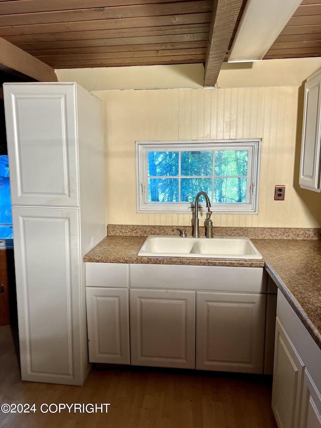 kitchen with dark hardwood / wood-style floors, beam ceiling, wooden ceiling, and sink