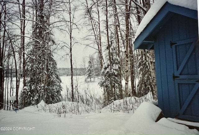 snow covered property with a storage shed