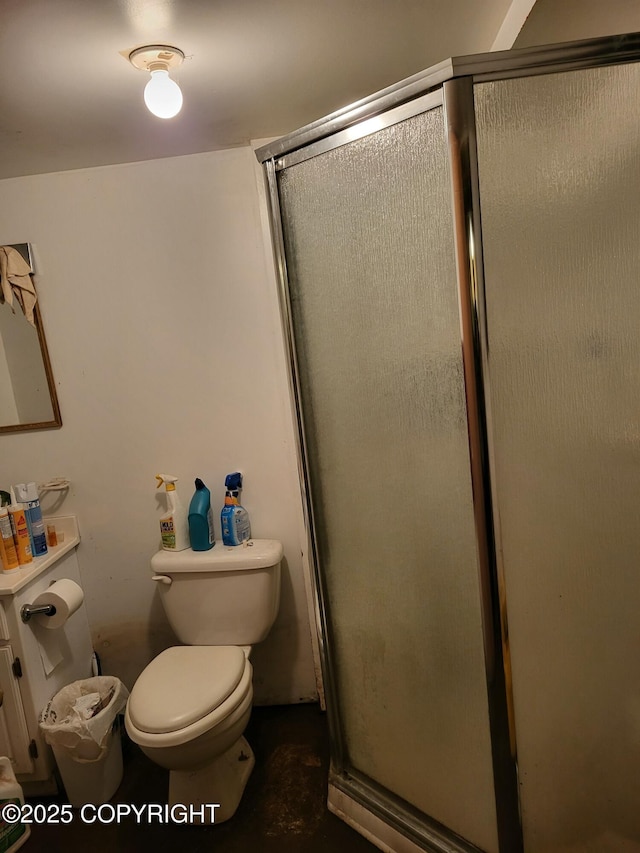 bathroom with a shower with door and toilet