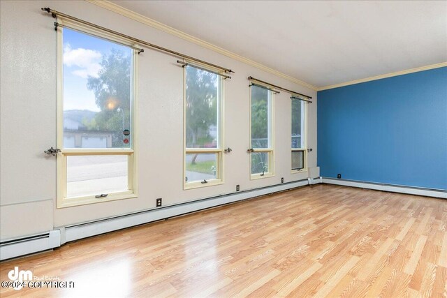 unfurnished room with ornamental molding, light wood-type flooring, and baseboard heating