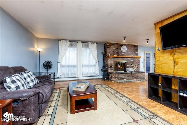 living room with a fireplace, baseboard heating, and hardwood / wood-style flooring