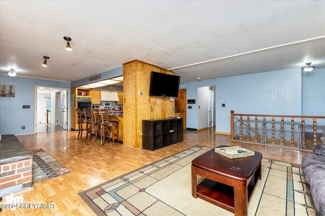 living room with wood-type flooring and a textured ceiling