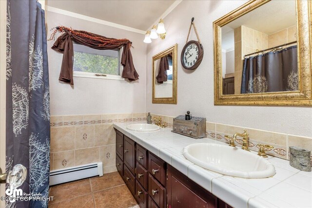 bathroom with a baseboard radiator, tile patterned floors, ornamental molding, vanity, and curtained shower