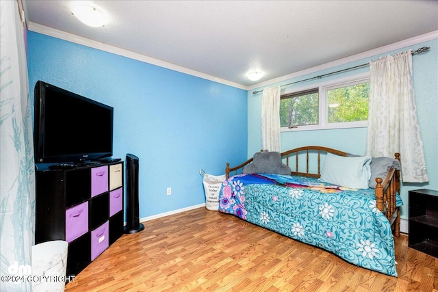 bedroom featuring wood-type flooring and ornamental molding