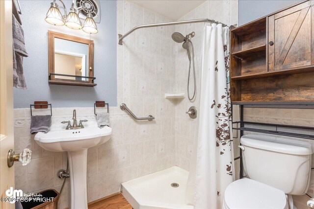 bathroom featuring tile walls, toilet, hardwood / wood-style flooring, and curtained shower