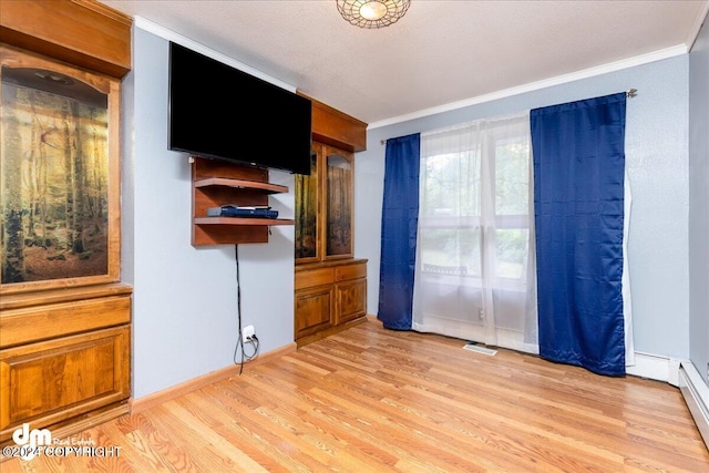 unfurnished bedroom featuring ornamental molding and light wood-type flooring