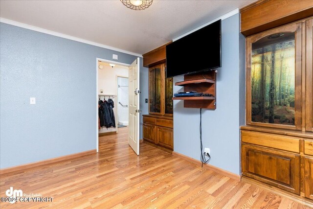 bedroom featuring light wood-type flooring and crown molding