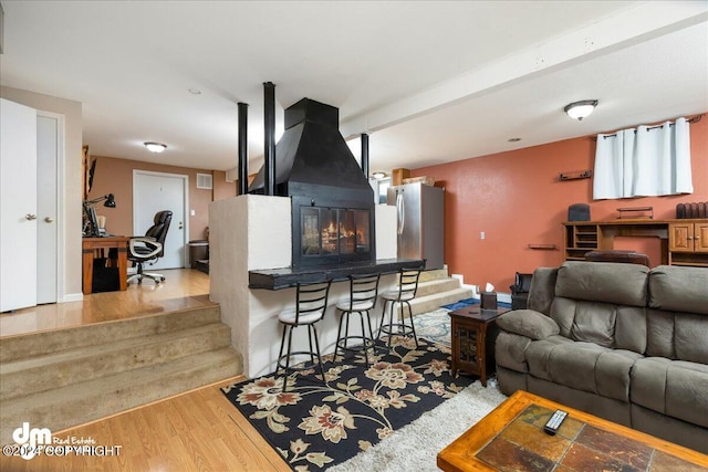 living room with light hardwood / wood-style floors and beam ceiling