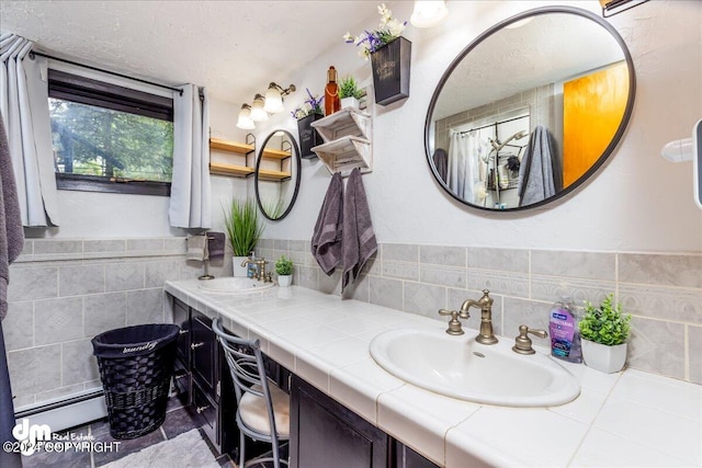 bathroom with tile walls, vanity, and a baseboard heating unit