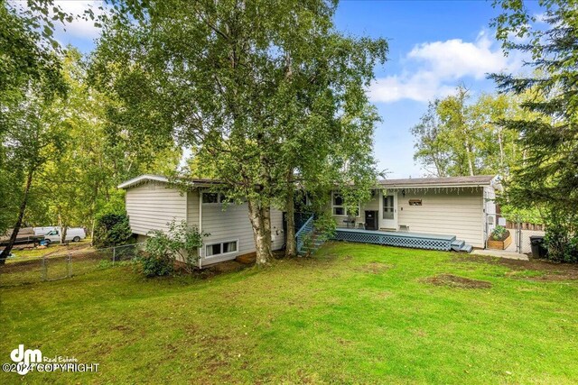 rear view of house featuring a yard