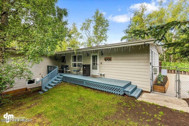 rear view of house with a lawn and a deck