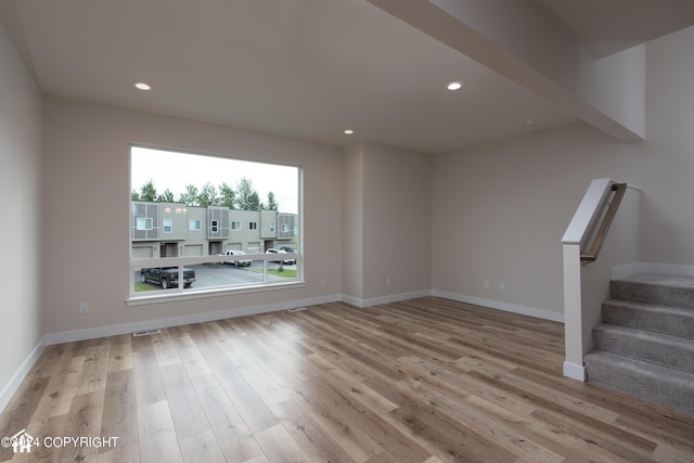 unfurnished room with recessed lighting, stairway, baseboards, and wood finished floors