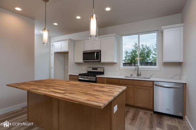 kitchen featuring recessed lighting, a sink, light wood-style floors, appliances with stainless steel finishes, and butcher block counters