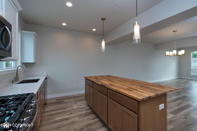 kitchen featuring a sink, light wood-style floors, stainless steel appliances, and butcher block counters