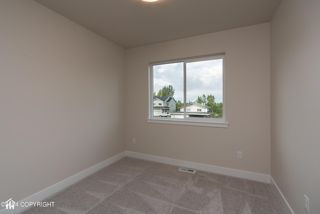 unfurnished room with visible vents, carpet flooring, and baseboards