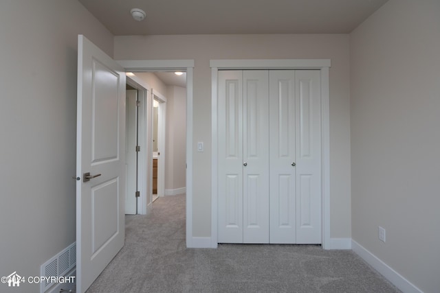 unfurnished bedroom with a closet, carpet flooring, baseboards, and visible vents