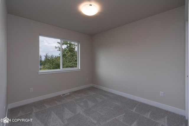 carpeted empty room with visible vents and baseboards