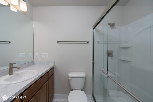 full bath featuring baseboards, vanity, toilet, and a shower stall