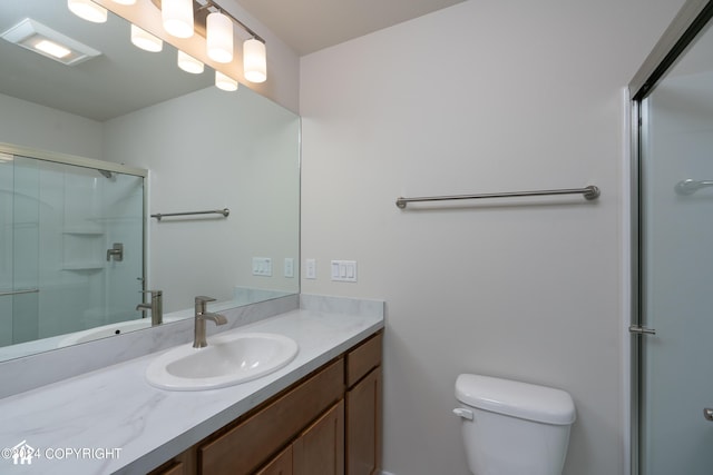 full bathroom with vanity, toilet, and a shower with shower door