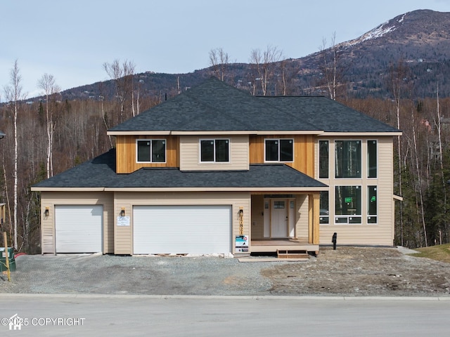 17821 Rivervista Rd, Eagle River, AK 99577 - view of front facade with driveway, a shingled roof, covered porch, and a mountain view