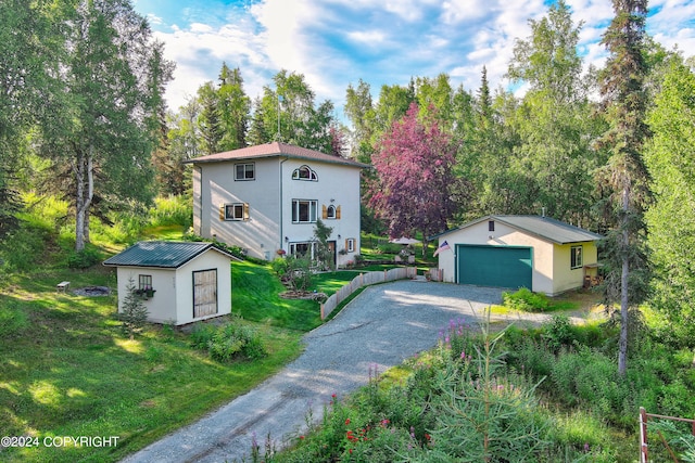 mediterranean / spanish house featuring a garage, a front yard, and a storage shed