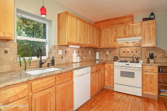 kitchen featuring white appliances, sink, light hardwood / wood-style flooring, decorative backsplash, and a textured ceiling